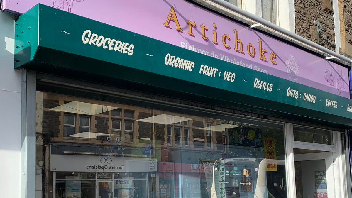 Storefront with 'Artichoke' sign and outdoor seating area.